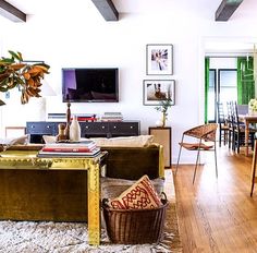 a living room filled with lots of furniture and a tv mounted on top of a wall