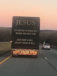 a truck driving down the road with a message written on it's back end