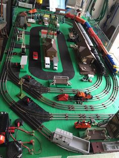 a toy train set is on display in a room with green flooring and white walls