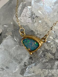 "Australian Opal 22k Gold Pendant Necklace This beautiful Opal is known as a Coober Pedy from the town of the same name, referred to as the \"opal capital of the world.\"  Wrapped in a 22k Gold bezel, a perfect backdrop to display all the vibrant color play of blue, purple, green, red and more. It is photographed in natural daylight and gorgeous at any angle. A solid 22k Gold granulation bead at bottom adds an additional point of interest. It is backed in 10k Gold and dangles from a 14k Gold chain with 18k Gold \"S\" clasp and links." Formal Gold Ethiopian Opal Jewelry, Formal Ethiopian Opal Gold Jewelry, Gold Opal Round Necklaces, Gold Opal Round Necklace, Heirloom Opal Jewelry In Yellow Gold, Gold Cabochon 14k Gold Necklace, Gold Cabochon Necklace In 14k Gold, 14k Gold Necklace With Cabochon, Heirloom Yellow Gold Opal Jewelry