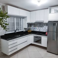 a kitchen with white cabinets and black counter tops