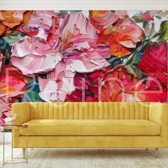 a yellow couch sitting in front of a wall with flowers on it's side