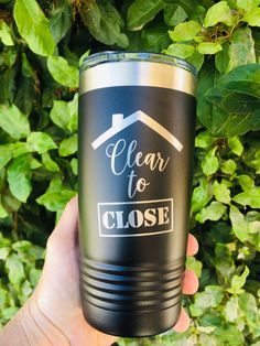 a person holding up a black tumbler with the words clear to close on it