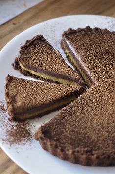 a chocolate cake on a white plate with one slice cut out