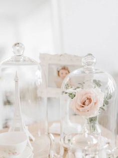 there is a glass dome with flowers in it on the table next to other items