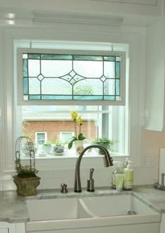 a white kitchen sink sitting under a window