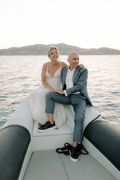 a man and woman sitting on the back of a boat