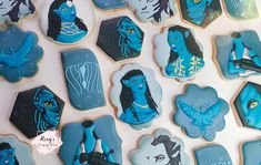 cookies decorated like avatars are displayed on a white surface with blue icing and frosting