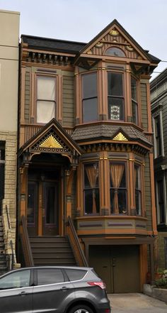 a car parked in front of a house with stairs leading up to the second floor