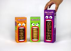 two boxes with cookies in the shape of monster's mouths and hands reaching for one