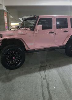 a pink jeep parked in a parking garage