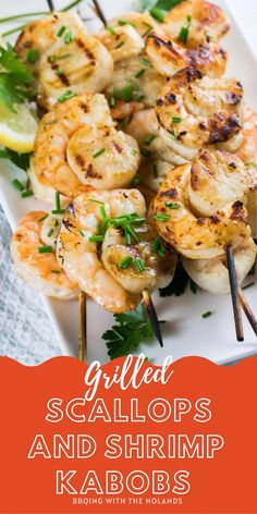 grilled scallops and shrimp kabobs on a white plate with lemon wedges