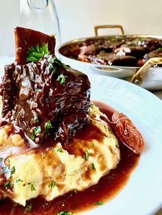 a white plate topped with meat covered in gravy