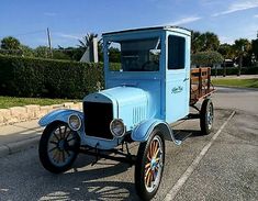 an old blue truck parked in a parking lot