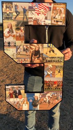 a man holding up a large letter made out of photos