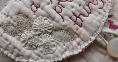 a close up of a piece of cloth with flowers on it and a bead in the middle