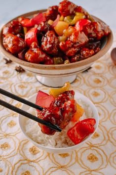 two bowls filled with food sitting on top of a table next to each other and chopsticks sticking out of them