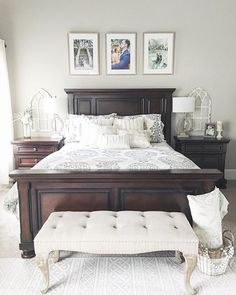 a bedroom with a bed, bench and pictures on the wall