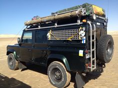 an off road vehicle is parked in the desert with its roof up and luggage on top