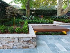 a stone bench in the middle of a garden