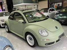 several different colored cars are parked in a showroom