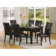 a dining room table with black chairs and a white rug on top of the floor