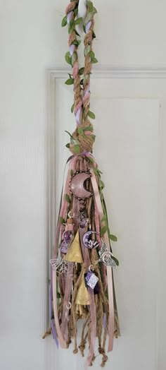 a bunch of ribbons hanging from the side of a white door with flowers on it