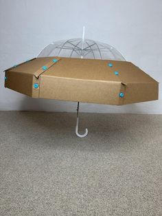 an open umbrella sitting on top of a floor next to a box with blue dots