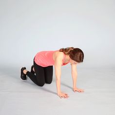 a woman in pink shirt and black pants doing push ups