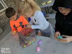 three children are playing with easter eggs on the table