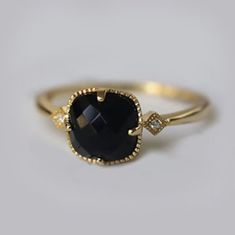 a gold ring with a black stone and diamonds