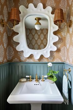 a white sink sitting under a bathroom mirror next to a wall mounted faucet