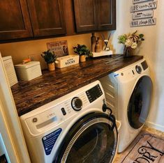 a washer and dryer in a small room with wooden cabinets on the wall