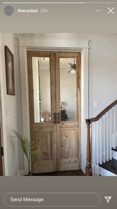 an image of a wooden door in the entry way to a house with white walls