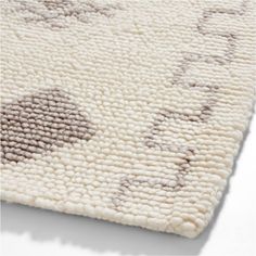 a white rug with brown and beige designs on it's sides, in the shape of circles