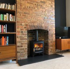 a living room with a fire place next to a book shelf and bookshelf