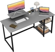 a computer desk with two laptops and a phone on it, sitting next to each other