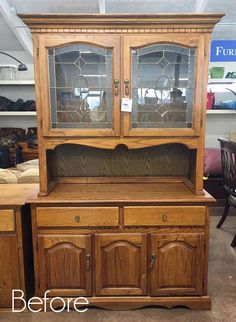 a wooden china cabinet with glass doors and drawers on display in a furniture store or showroom