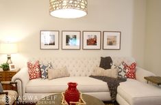 a living room with white couches and pictures on the wall above them in various frames