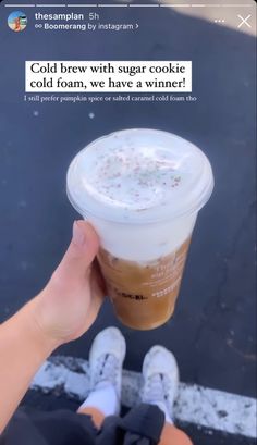 someone is holding up a cold drink in their left hand and the caption reads, cold brew with sugar cookie cold foam, we have a winter