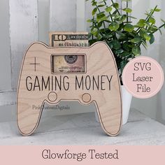 a wooden game controller with the words gaming money on it and a potted plant