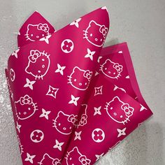 pink paper with white hello kitty designs on it