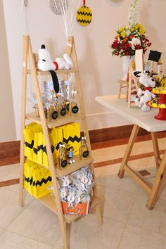 a display case with yellow and black items on it next to a white table in a room