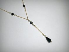 "Genuine black onyx necklace, a lariat necklace with Swarovkski crystals, in 14K yellow gold filled. The black onyx tear drop measures 15mm, the black onyx beads measure 6mm. Suspended from a 14K yellow gold filled chain, a \"cable\" style, 1.5mm in width, 16 inches in length. The \"drop\" measures approximately three inches in length.. Each onyx stone is accented with clear Swarovski crystals. This black onyx \"Y necklace\", or \"Y pendant\", is perfect gift for evening wear, or to match \"the Elegant Black Teardrop Drop Necklace, Elegant Black Drop Necklace, Elegant Black Drop Necklace Gift, Elegant Adjustable Onyx Necklace, Elegant Onyx Teardrop Necklaces, Elegant Onyx Drop Jewelry, Elegant Onyx Teardrop Necklace, Elegant Black Long Drop Jewelry, Elegant Black Dangle Drop Necklace