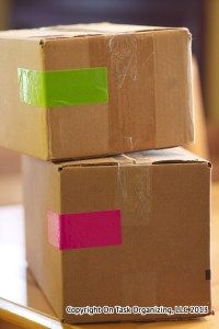 two boxes are stacked on top of each other with pink and green tape around them