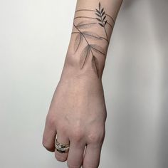 a person's hand with a small tattoo on the wrist and an olive branch