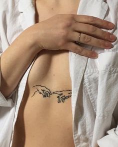 a woman's left side with the creation of hands tattoo on her upper back