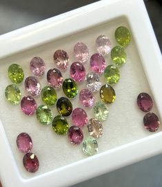 many different colored stones in a white tray