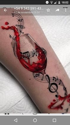 a tattoo with music notes and a red liquid pouring out of it