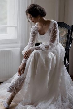 a woman in a white dress sitting on a chair